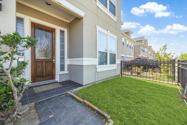 5309 Elm St, Houston, TX 77081 - view of exterior entry featuring a residential view, stucco siding, fence, and a yard