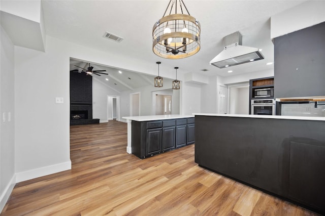 kitchen with stainless steel oven, visible vents, ceiling fan with notable chandelier, a brick fireplace, and black microwave