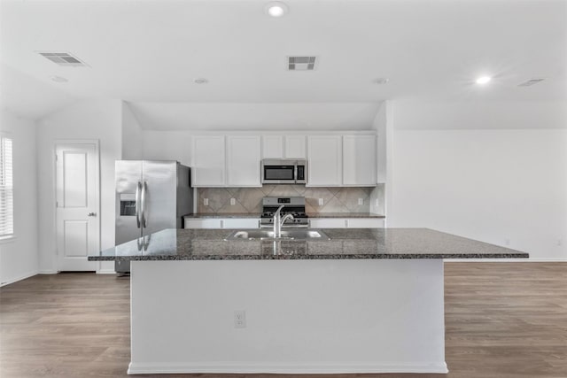 5135 Dunstable Manor Ln, Rosharon, TX 77583 - kitchen with stainless steel appliances, white cabinets, a sink, a center island with sink, and light wood-type flooring