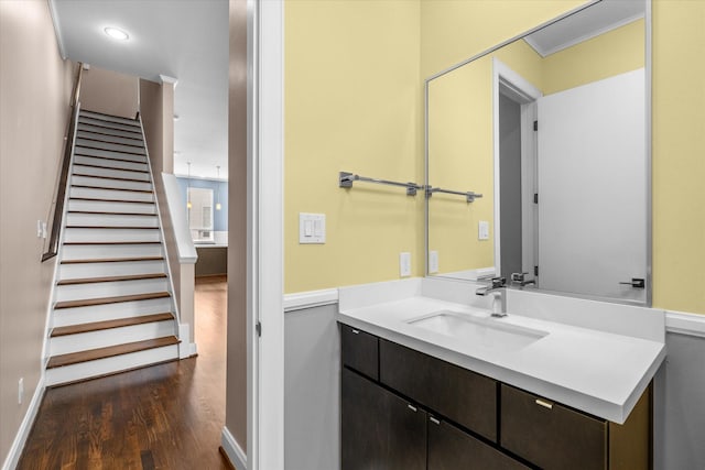 bathroom with vanity, baseboards, ornamental molding, and wood finished floors