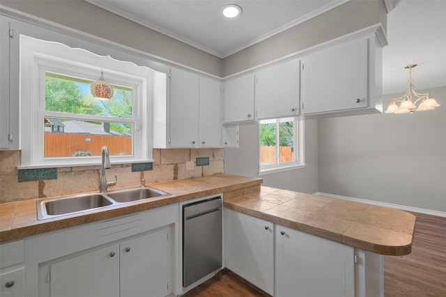 kitchen with a sink, a peninsula, stainless steel dishwasher, tile countertops, and decorative backsplash