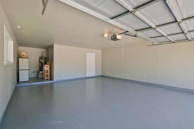 garage with water heater, a garage door opener, baseboards, and freestanding refrigerator