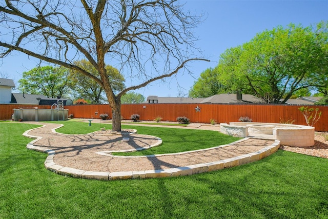 view of yard with a hot tub, a fenced backyard, and a pool