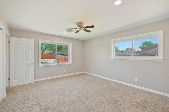 carpeted empty room with baseboards, visible vents, recessed lighting, and a ceiling fan