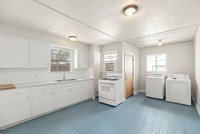4605 Norhill Blvd, Houston, TX 77009 - kitchen with washer and clothes dryer, light countertops, a sink, gas range gas stove, and white cabinetry