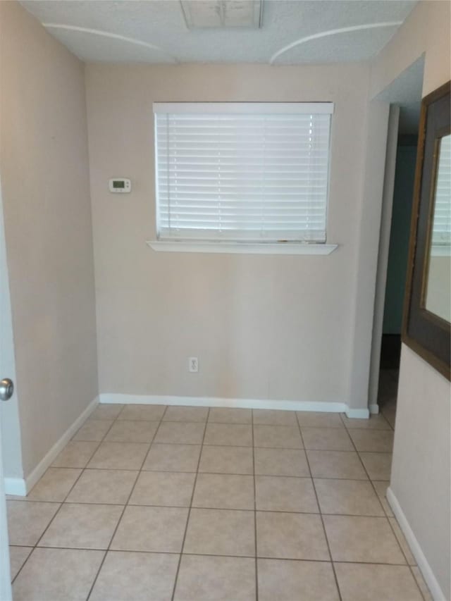 spare room with light tile patterned floors, baseboards, and visible vents