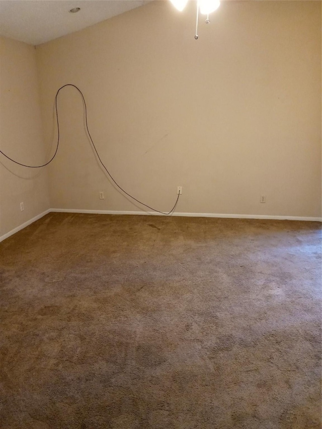 carpeted empty room featuring baseboards