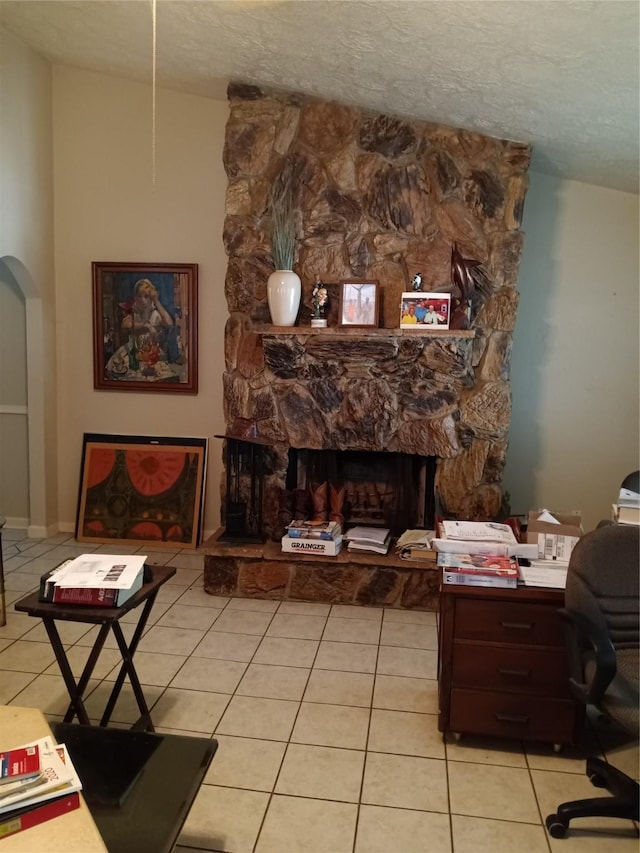 1372 Apache Dr, Montgomery, TX 77316 - living area with a fireplace, light tile patterned flooring, a desk, and a textured ceiling