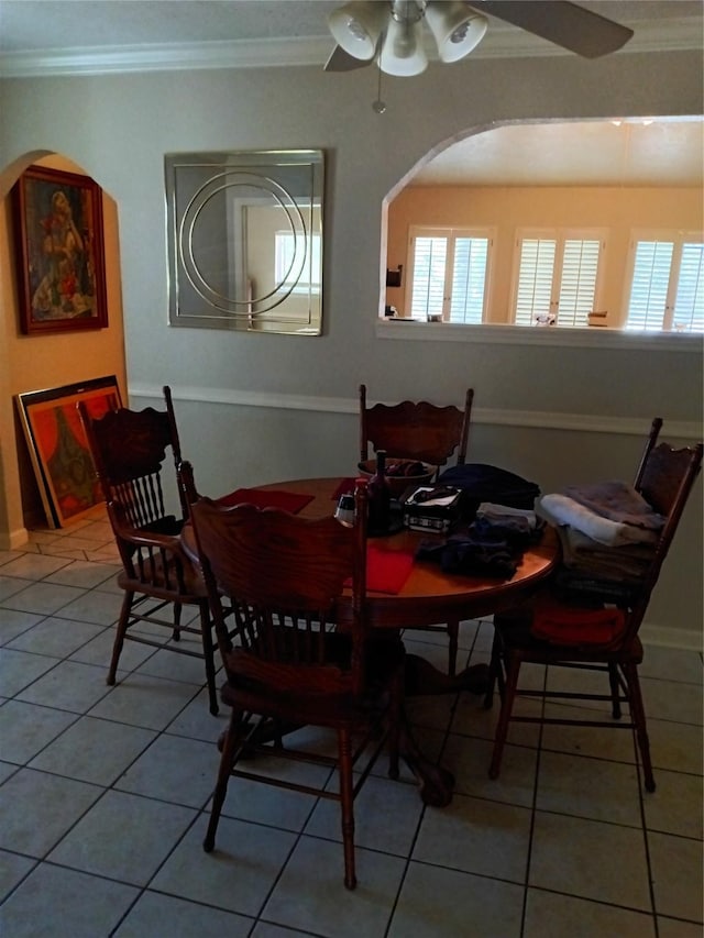 dining room with a wealth of natural light, ornamental molding, light tile patterned floors, and a ceiling fan