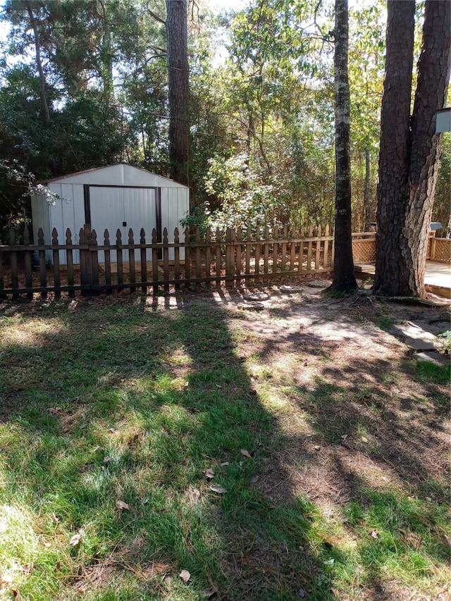 view of yard with an outbuilding, a shed, and fence