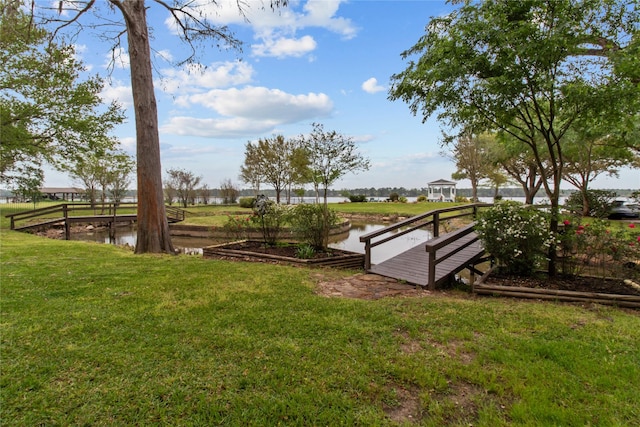 surrounding community with a yard and a water view