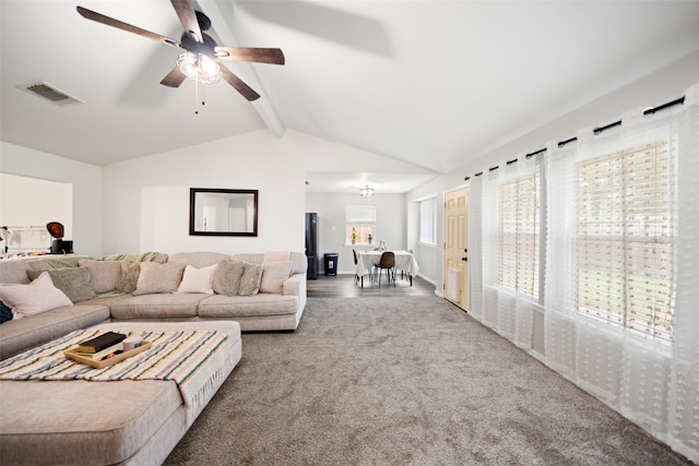 carpeted living area with a ceiling fan, lofted ceiling with beams, and visible vents
