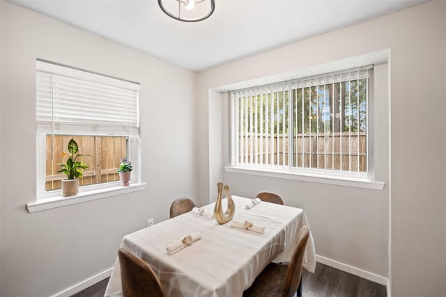 dining space featuring baseboards and wood finished floors