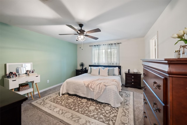 bedroom featuring light colored carpet, baseboards, and a ceiling fan