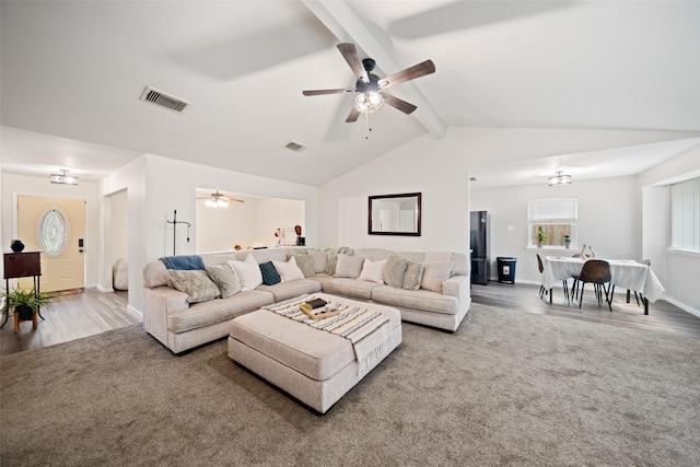 living area with a ceiling fan, lofted ceiling with beams, wood finished floors, and visible vents