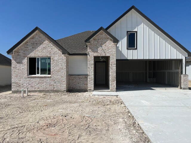 12520 Tarres Ct, Lorena, TX 76655 - view of front of house featuring stone siding, a garage, board and batten siding, driveway, and a shingled roof