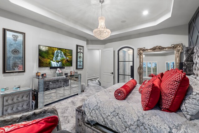 34 New Oak Trl, Humble, TX 77346 - bedroom featuring a raised ceiling, a chandelier, and arched walkways
