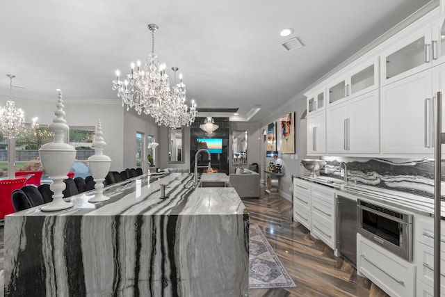 34 New Oak Trl, Humble, TX 77346 - kitchen featuring open floor plan, light stone countertops, a large island, a chandelier, and ornamental molding