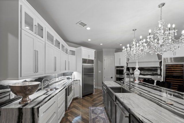 34 New Oak Trl, Humble, TX 77346 - kitchen featuring beverage cooler, light stone counters, visible vents, a sink, and appliances with stainless steel finishes