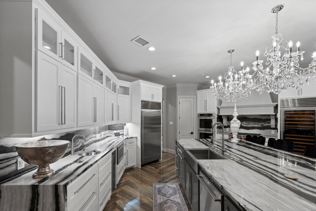 34 New Oak Trl, Humble, TX 77346 - kitchen featuring stainless steel appliances, wine cooler, a sink, a chandelier, and light stone countertops