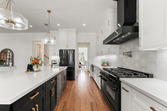 1107 Grovewood Ln, Houston, TX 77008 - kitchen featuring wall chimney exhaust hood, black appliances, dark cabinetry, white cabinetry, and light countertops