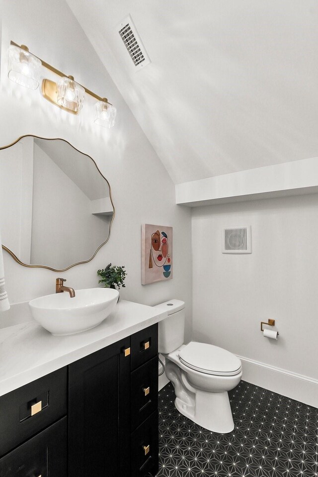 1107 Grovewood Ln, Houston, TX 77008 - bathroom featuring toilet, vanity, vaulted ceiling, and tile patterned floors