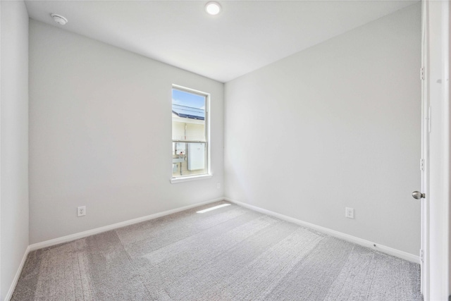carpeted empty room featuring baseboards