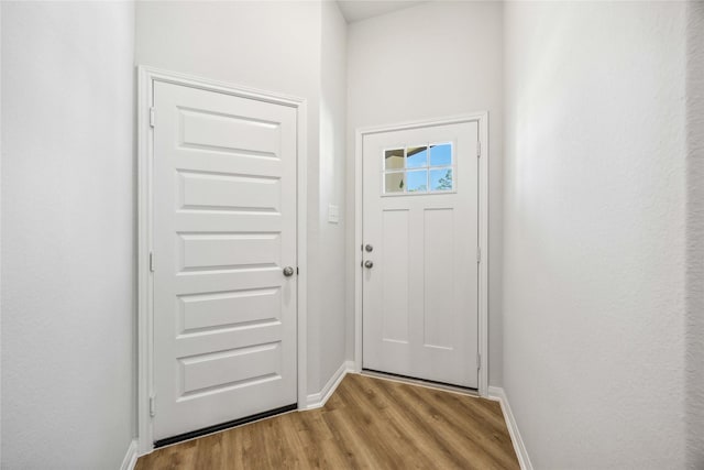 doorway to outside with wood finished floors and baseboards