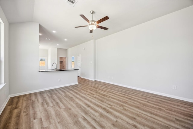 unfurnished living room featuring a sink, visible vents, recessed lighting, wood finished floors, and a ceiling fan