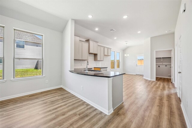 kitchen featuring baseboards, tasteful backsplash, dark countertops, and light wood-style flooring