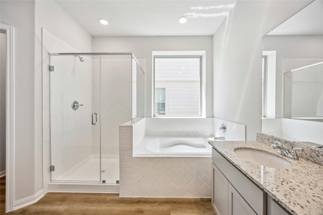 full bath with wood finished floors, a shower stall, a garden tub, and vanity