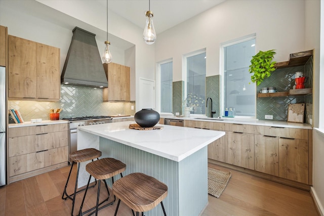 3905 Yale Heights Dr, Houston, TX 77018 - kitchen featuring custom exhaust hood, appliances with stainless steel finishes, light brown cabinets, a sink, and a kitchen breakfast bar