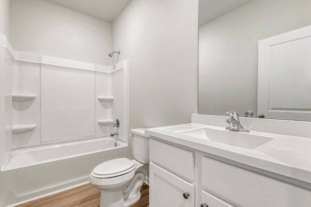 bathroom with toilet, vanity, shower / washtub combination, and wood finished floors