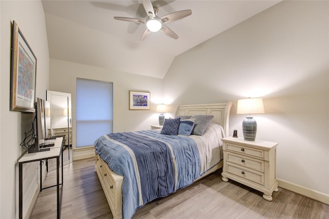 bedroom featuring baseboards, lofted ceiling, light wood finished floors, and ceiling fan