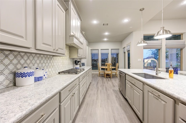 kitchen with light countertops, light wood-type flooring, a sink, visible vents, and appliances with stainless steel finishes