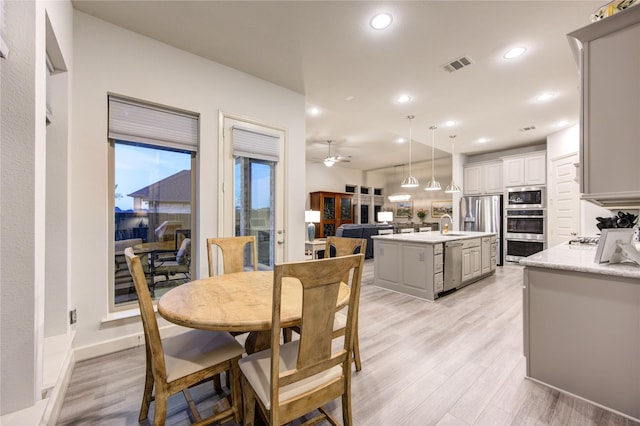 dining area with light wood-style flooring, visible vents, recessed lighting, and ceiling fan