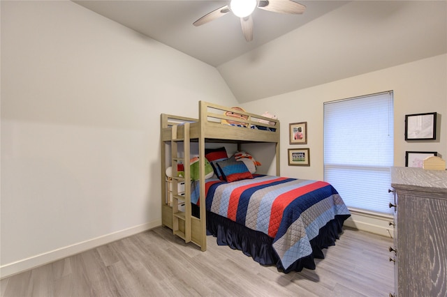 bedroom with baseboards, wood finished floors, vaulted ceiling, and a ceiling fan