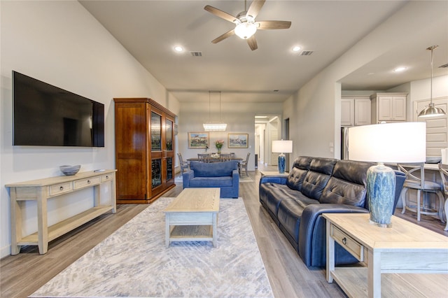 living area featuring a ceiling fan, recessed lighting, light wood finished floors, and visible vents