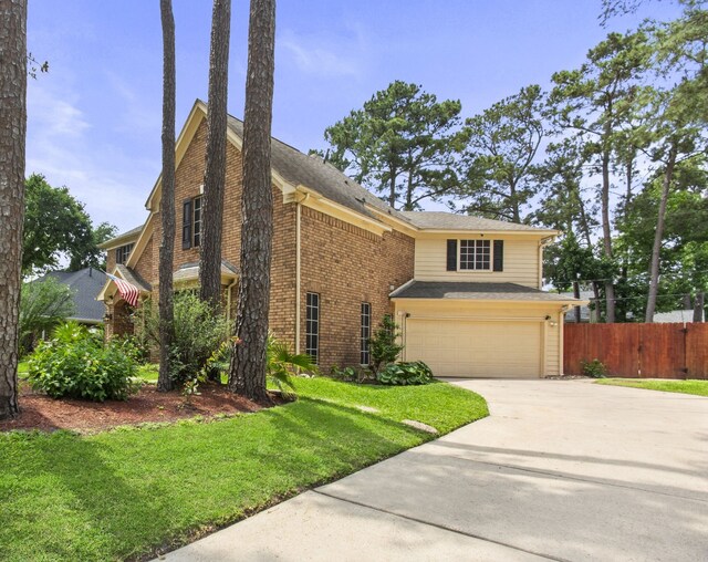view of front of house with fence, an attached garage, brick siding, a front yard, and concrete driveway
