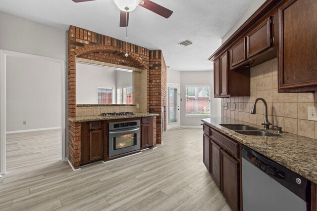 kitchen featuring visible vents, a ceiling fan, baseboards, a sink, and stainless steel appliances
