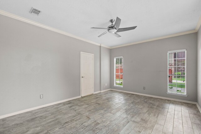 spare room with ceiling fan, visible vents, plenty of natural light, and wood finished floors
