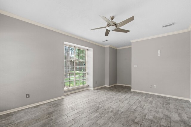 unfurnished room featuring ornamental molding, a ceiling fan, wood finished floors, and visible vents