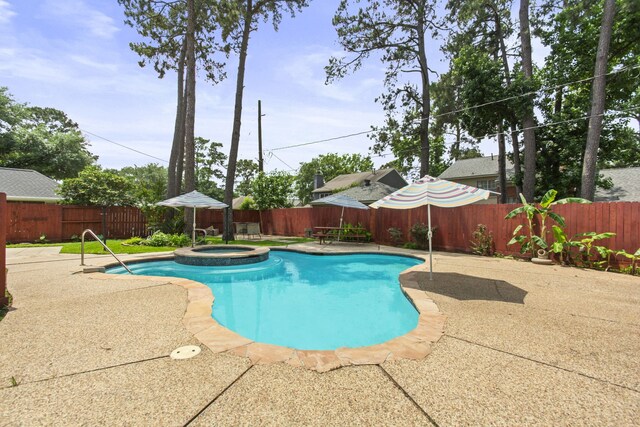 view of pool with a patio, a pool with connected hot tub, and a fenced backyard