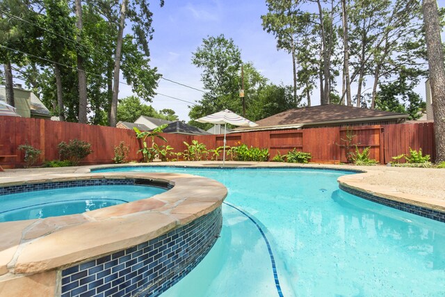 view of pool featuring an in ground hot tub, a fenced in pool, and a fenced backyard