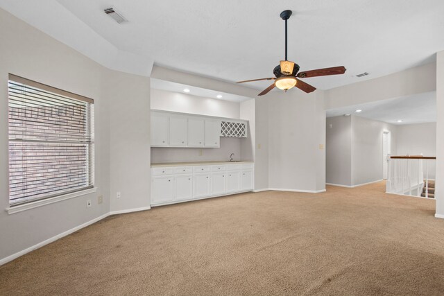 unfurnished living room with baseboards, a ceiling fan, recessed lighting, and light carpet
