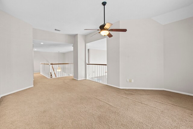 carpeted spare room featuring ceiling fan, visible vents, and baseboards