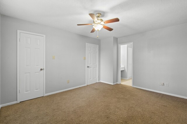 unfurnished bedroom featuring carpet flooring, a ceiling fan, baseboards, and connected bathroom