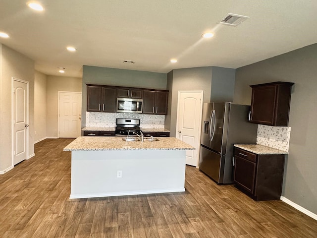 kitchen featuring dark brown cabinets, dark wood-style floors, a sink, and stainless steel appliances
