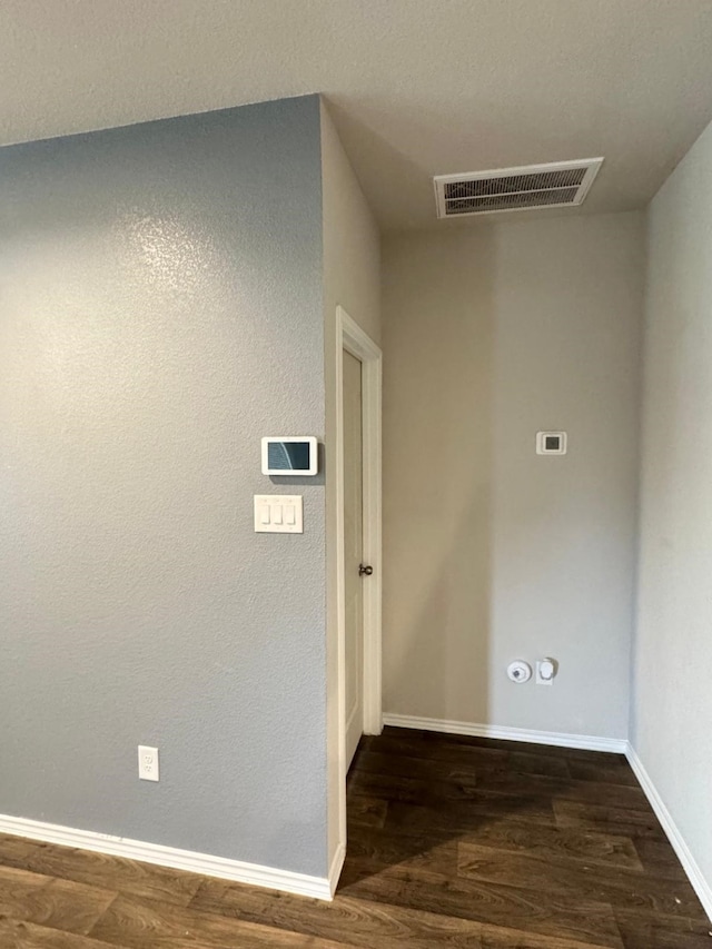 hallway featuring baseboards, visible vents, and dark wood finished floors