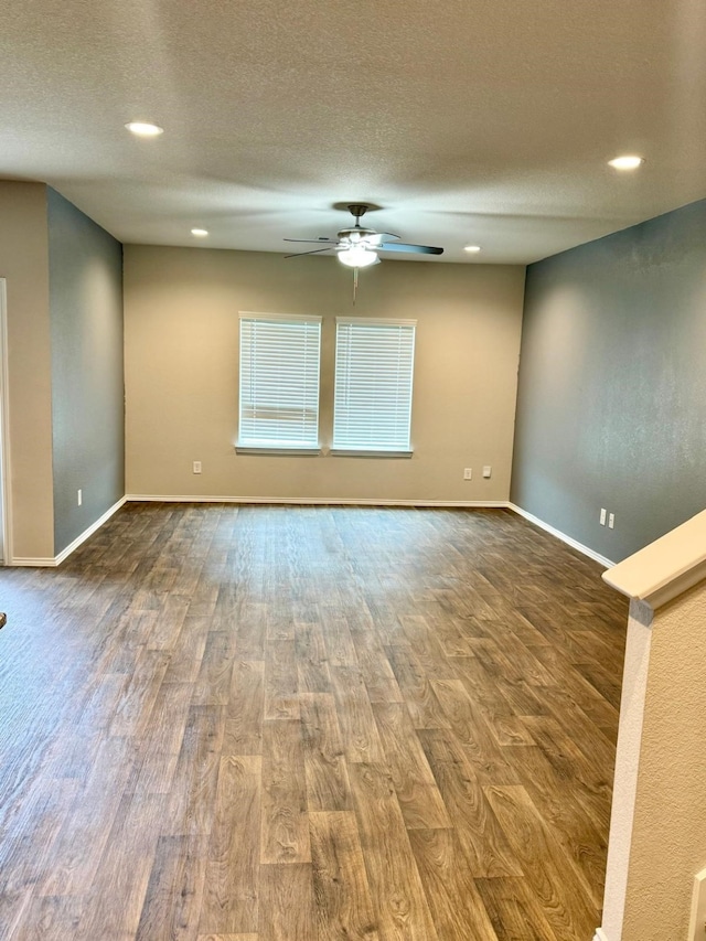 spare room with a ceiling fan, dark wood-style flooring, baseboards, and a textured ceiling